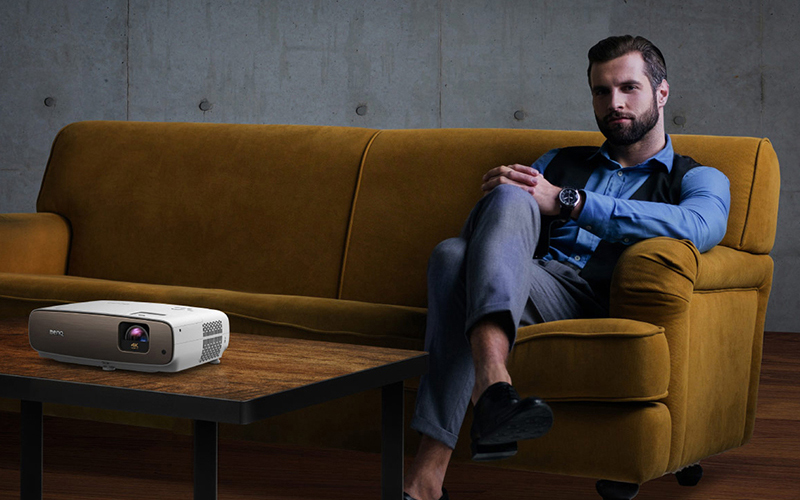 Ein Mann genießt  in seinem Heimkinoraum den BenQ 4K Beamer